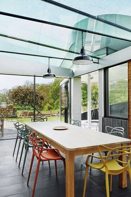 A classic conservatory in white uPVC with open doors displaying a dining  table inside