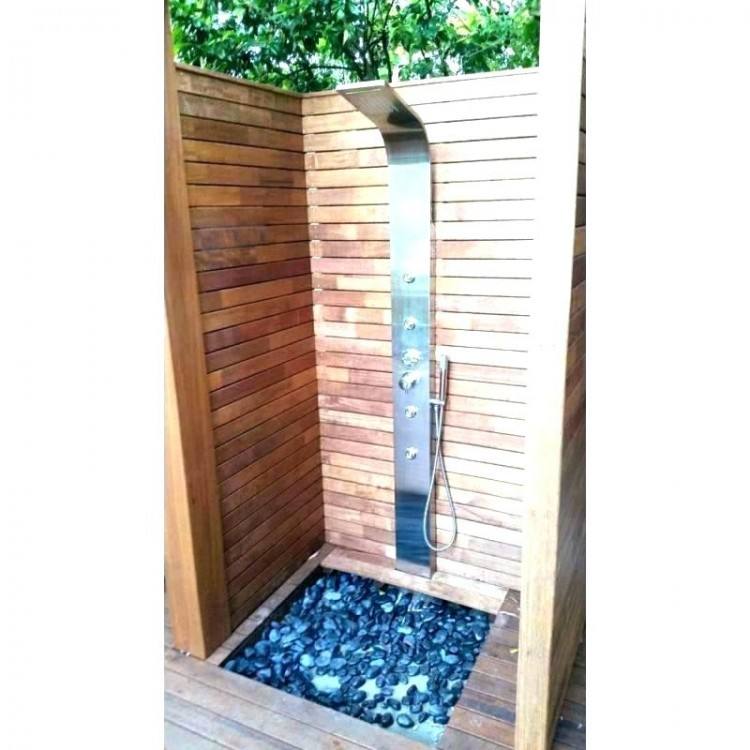White and gray cement wall tiles accent an open outdoor shower featuring an oil rubbed bronze rain shower head, as three oil rubbed bronze coat hooks are