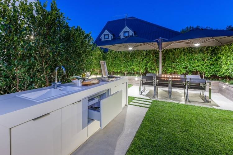 The partially covered outdoor living space boasts a open fire/barbeque