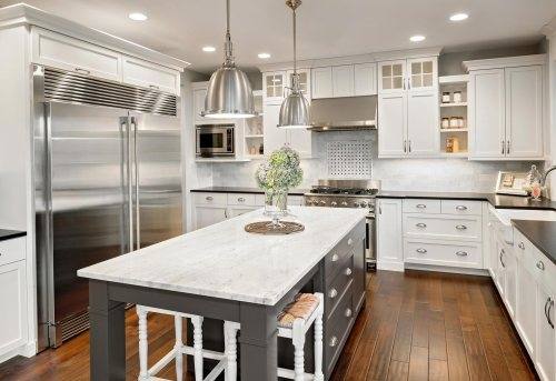 Off white glazed cabinets with a dark kitchen island