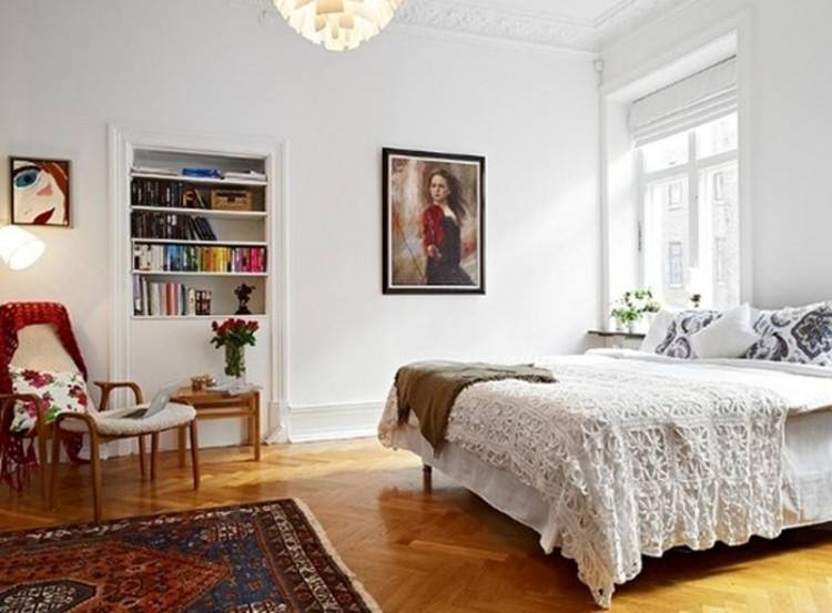 Scandinavian master bedroom with hardwood floor and accent chair